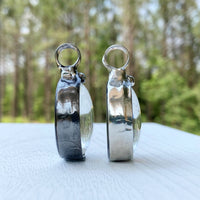 2 bayou Glass Arts pendant side by side to show the difference in finish options. Left is gunmetal shiny black finish. Right is shiny Silver finish.
