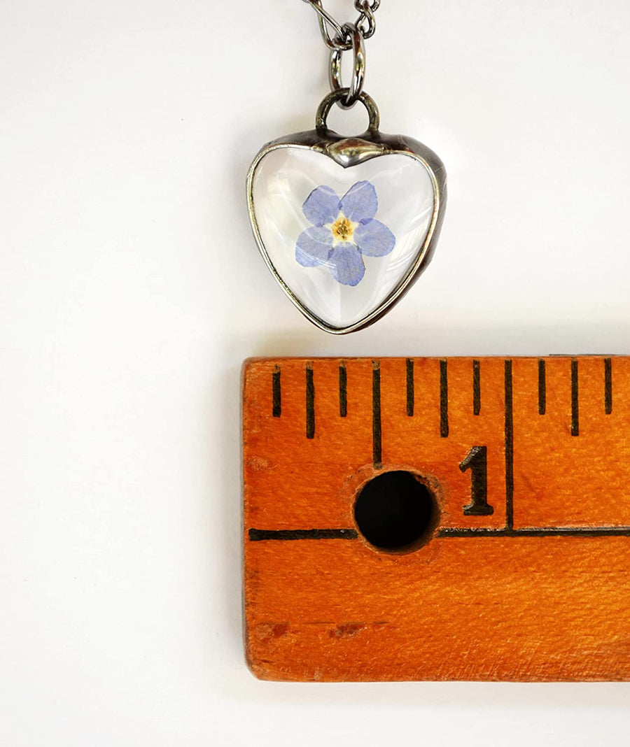 Dainty Real Pressed Flower Heart Charm Pendant Necklace shown next to a ruler for size comparison. 3/4 inch x 3/4 inch.