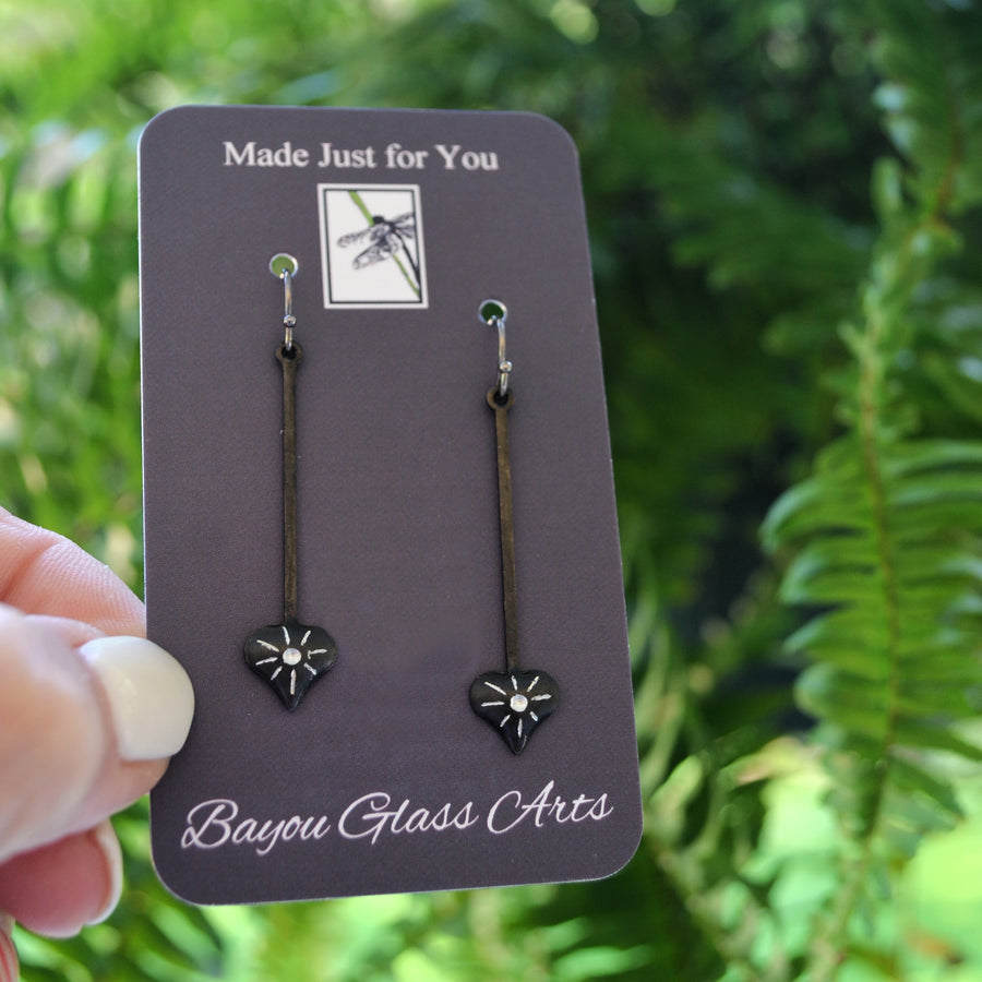 Sterling silver ear wires attached to long dangle earring with hearts and starburst
