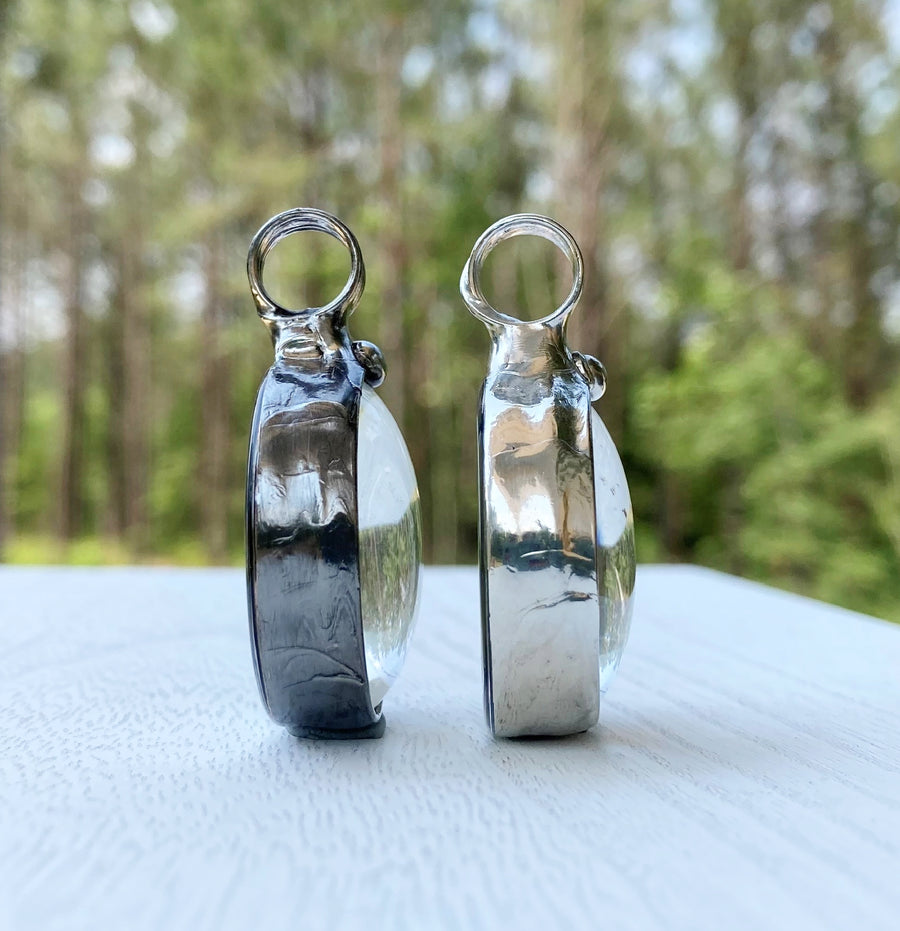 Two Bayou Glass Arts Pendants side by side to show difference in finish. On the left  is gunmetal shiny black and on the right is shiny silver finish. Truly Hand Made in USA by Louisiana Artisans at Bayou Glass Arts Studio.