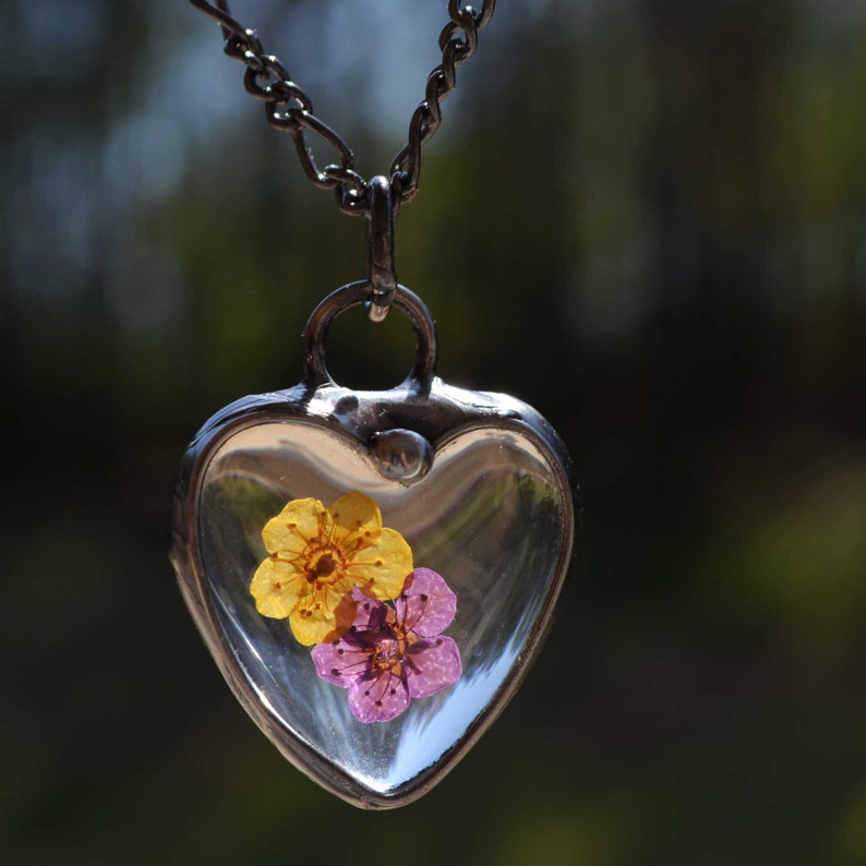 Yellow and Purple Forget Me not flowers encased in Heart shaped glass creating this lovely pendant necklace. Hand Made in USA