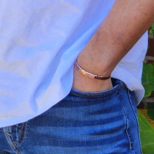 male model wearing 1 copper cuff bracelet. Come in 3 different styles.Full hand hammered, edge and bark. Each has a different look. Truly Hand made in Louisiana USA at Bayou Glass Arts Studio.