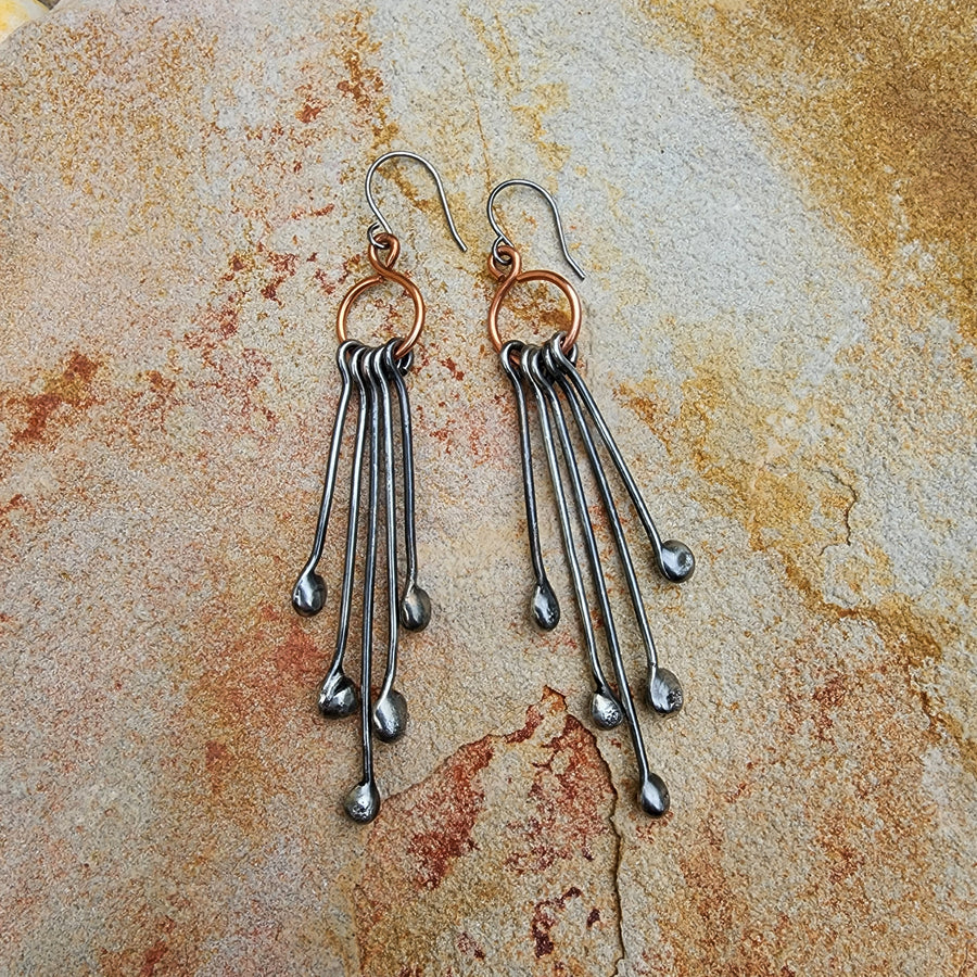 Long Handmade Earrings look like chandeliers. Sterling Silver Ear Wires hold Copper infinity circles that hold 5 individual metal pins with drips on the end. Together these earrings create great movement and are great with long hair or short.
