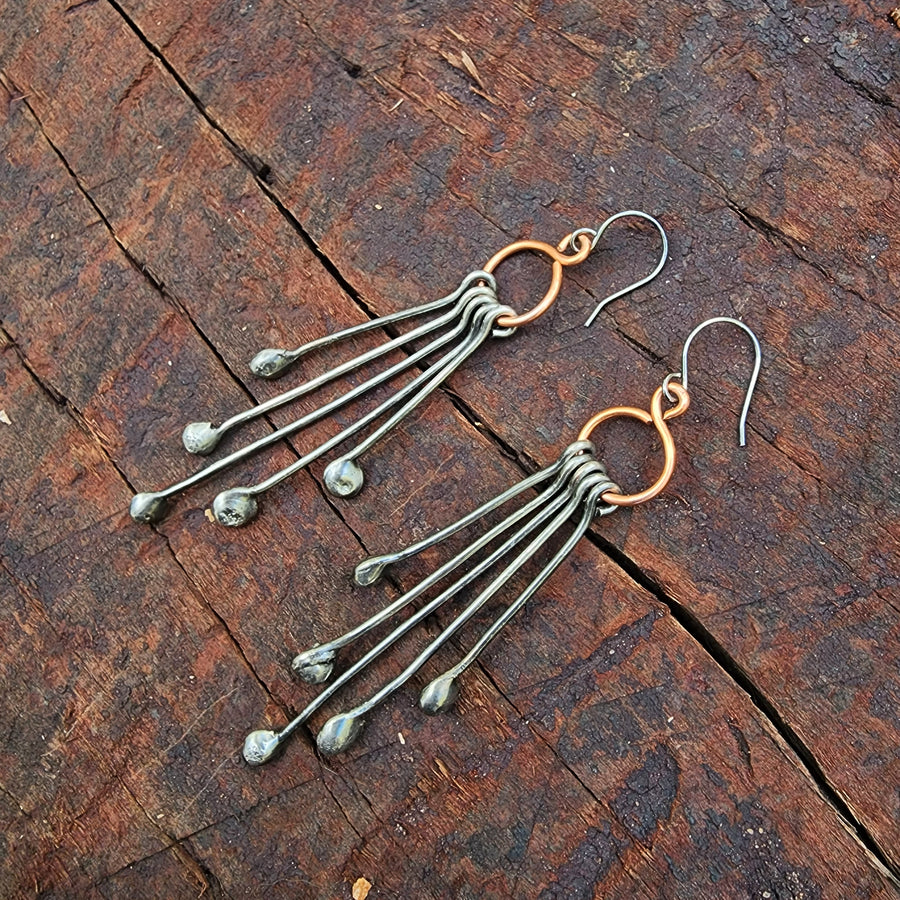 Long Handmade Earrings look like chandeliers. Sterling Silver Ear Wires hold Copper infinity circles that hold 5 individual metal pins with drips on the end. Together these earrings create great movement and are great with long hair or short.