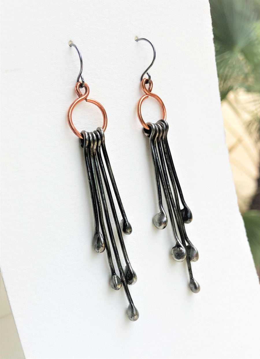 Long Handmade Earrings look like chandeliers. Sterling Silver Ear Wires hold Copper infinity circles that hold 5 individual metal pins with drips on the end. Together these earrings create great movement and are great with long hair or short.