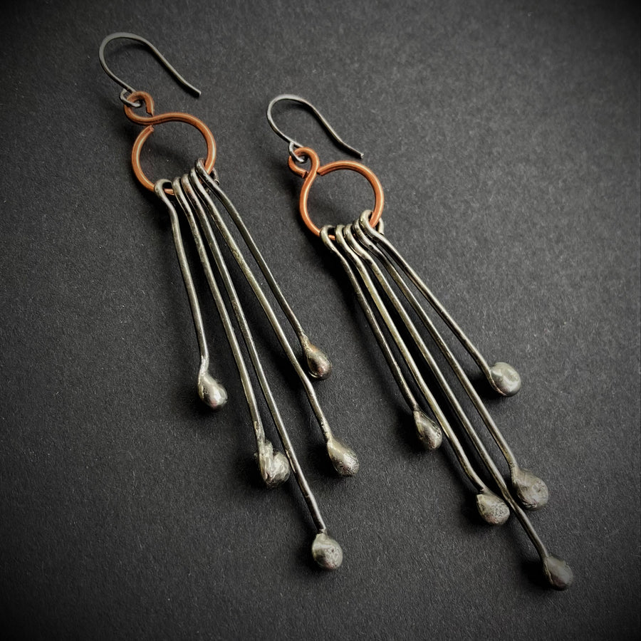 Long Handmade Earrings look like chandeliers. Sterling Silver Ear Wires hold Copper infinity circles that hold 5 individual metal pins with drips on the end. Together these earrings create great movement and are great with long hair or short.