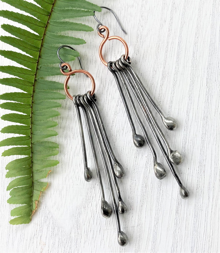 Long Handmade Earrings look like chandeliers. Sterling Silver Ear Wires hold Copper infinity circles that hold 5 individual metal pins with drips on the end. Together these earrings create great movement and are great with long hair or short.