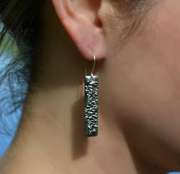 Rectangle tag earrings on model. Handmade in silver finish. Looks like a Skyscraper building.Truly Hand Made in USA by Louisiana Artisan at Bayou Glass Arts Studio. Chain is quality plated fully adjustable Figaro style. All are 100% handmade from metals that contain NO lead, cadmium, zinc or nickel. 