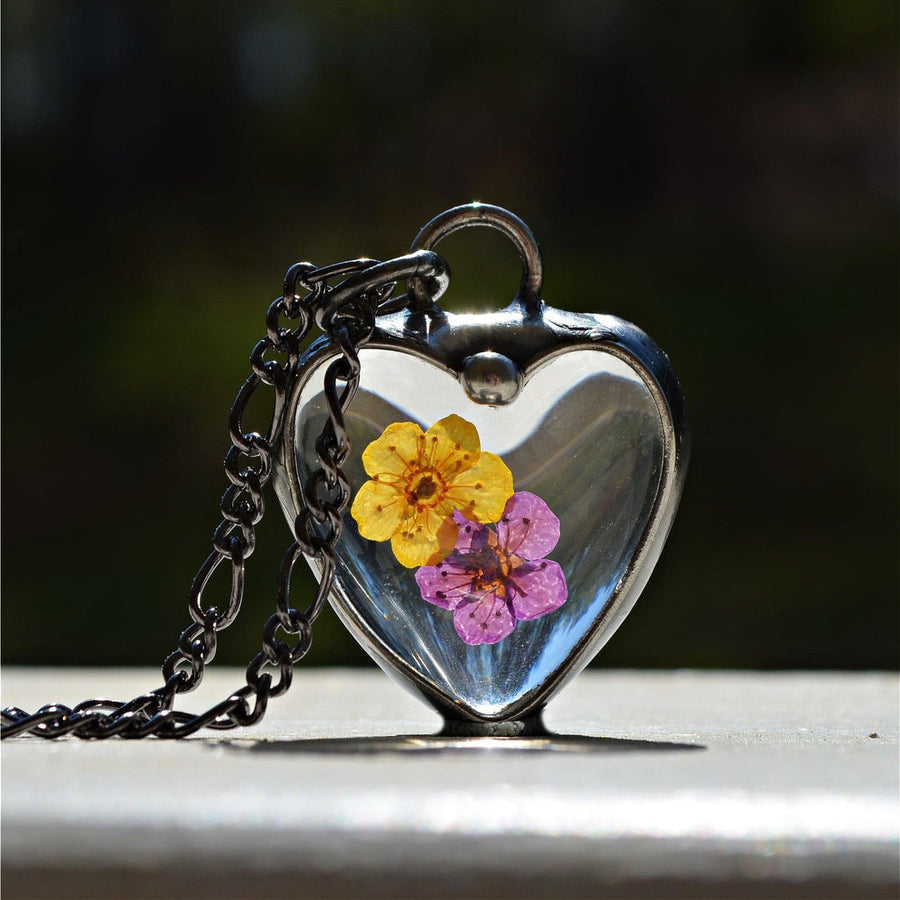 Handmade Heart Necklace made of Glass Hearts with a purple forget me not and a yellow forget me not pressed flowers inside. Artisan made at Bayou Glass Arts studio in Louisiana. Hand Made in USA. 