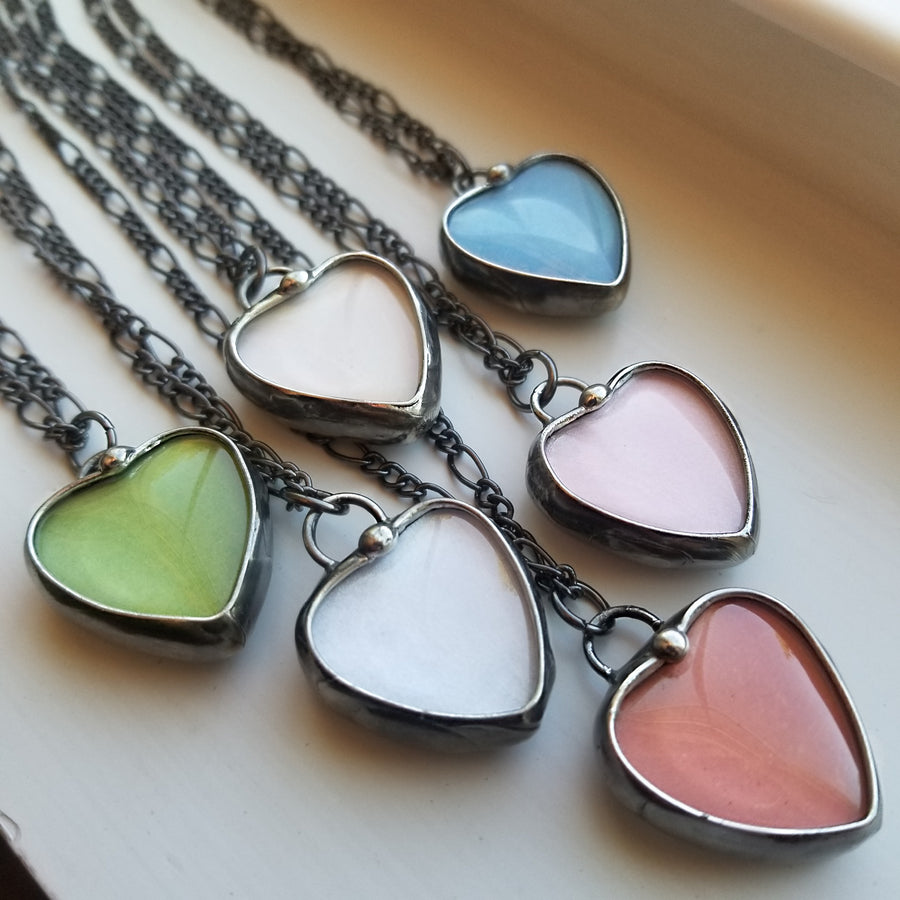 6 assorted colors of Handmade Heart See See Necklaces. Green, Peach, Blue, White, Pink, Orange. See See Jewelry is hand made in USA by Louisiana Artisan at Bayou Glass Arts Studio. Secret message hidden inside is revealed when pendant is held up to a light.