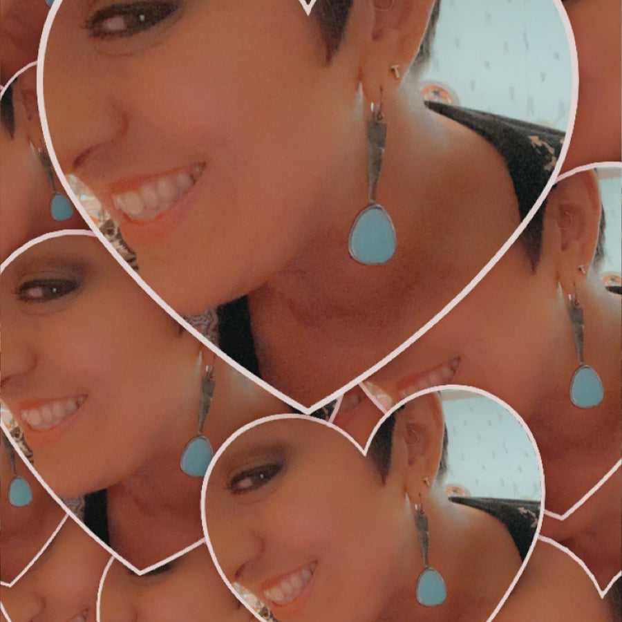 Model wearing Long dangle earrings with turquoise colored mosaics at the end of a metal band, similar to exclamation mark shape. Comes with Sterling Silver ear wires.
