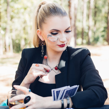 model using handheld monocle to view her cards. 