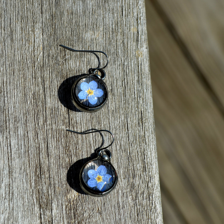  Forget me not earrings on sterling silver ear wires. One blue bloom inside each round glass earring, bezel is hand formed with copper and mixed silver solder by Louisiana Artisan. Hand made in USA.