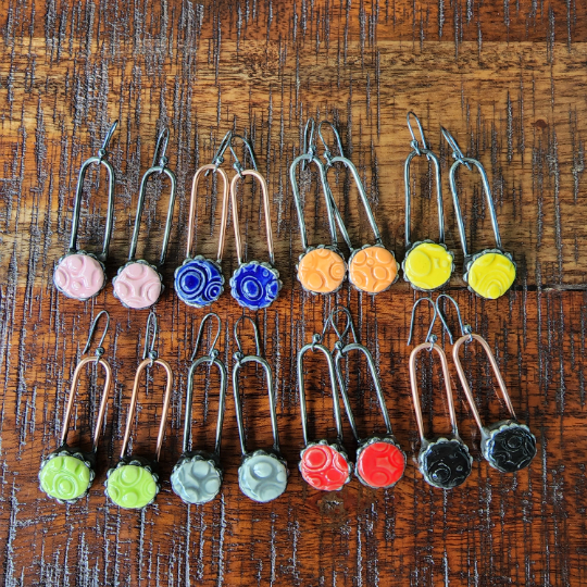 8 sets of earrings in an assortment of colors, ceramic dots like a button on copper or gunmetal finished wires hanging on sterling silver ear wires