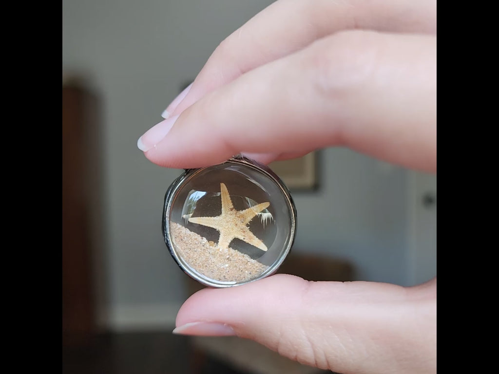 Video showing movement inside this starfish and sand terrarium necklace. 