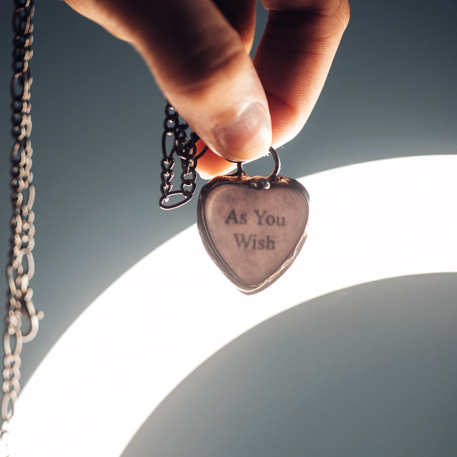 See See Heart Pendant Necklace being held up to bright light to show the hidden message inside.See See Jewelry is hand made in USA by Louisiana Artisan at Bayou Glass Arts Studio. Secret message hidden inside is revealed when pendant is held up to a light.
