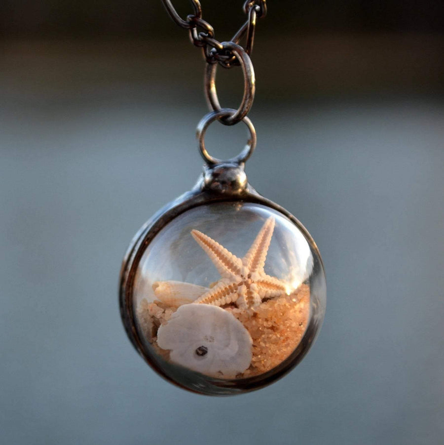 Starfish_Beach_Necklace Beach Terrarium Orb Necklace filled with starfish sand and shells. One side is magnified. Loose items create this shaker pendant. Truly Hand Made in USA by Louisiana Artisan at Bayou Glass Arts. Great gift for Mom wife girlfriend grandmother sister Christmas Birthday