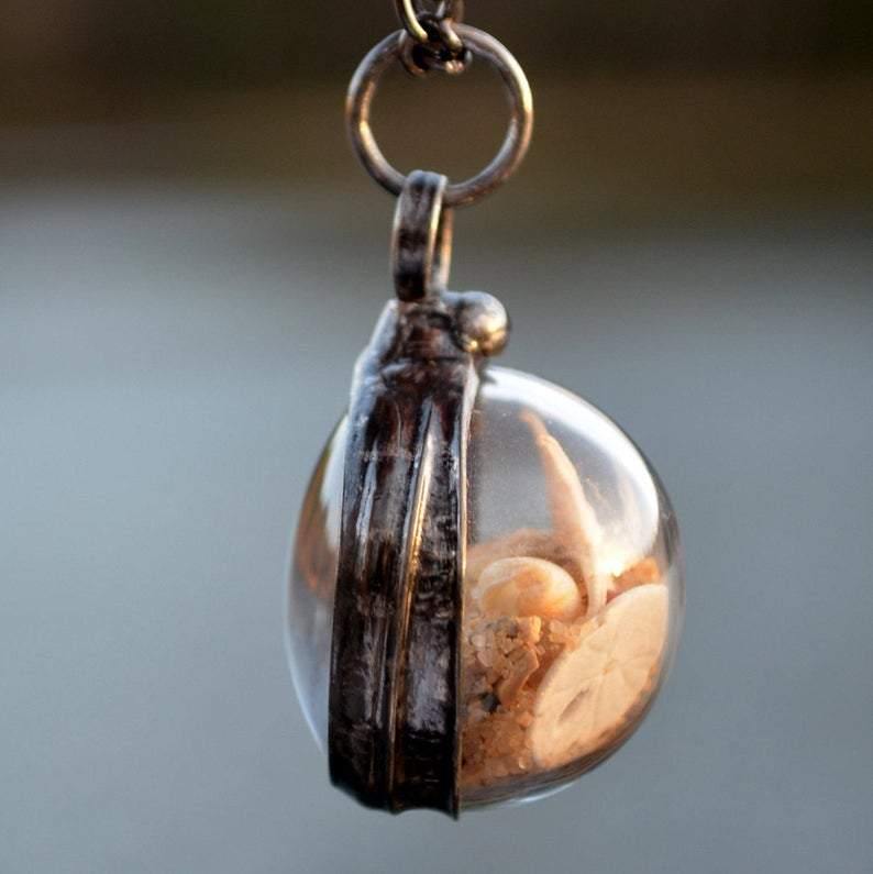 Side_Beach_Terrarium_Pendant Beach Terrarium Orb Necklace filled with starfish sand and shells. One side is magnified. Loose items create this shaker pendant. Truly Hand Made in USA by Louisiana Artisan at Bayou Glass Arts. Great gift for Mom wife girlfriend grandmother sister Christmas Birthday