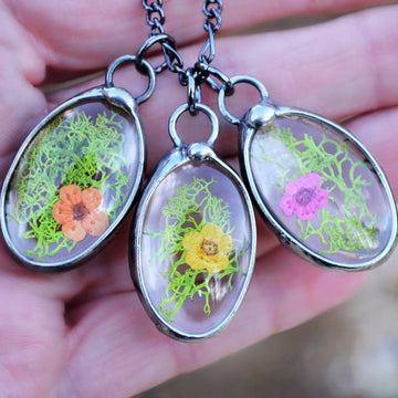 3 oval pendants with Green Moss and small floret on each 1st one has orange 2nd has yellow 3rd has pink.  Great Nature Lover gift