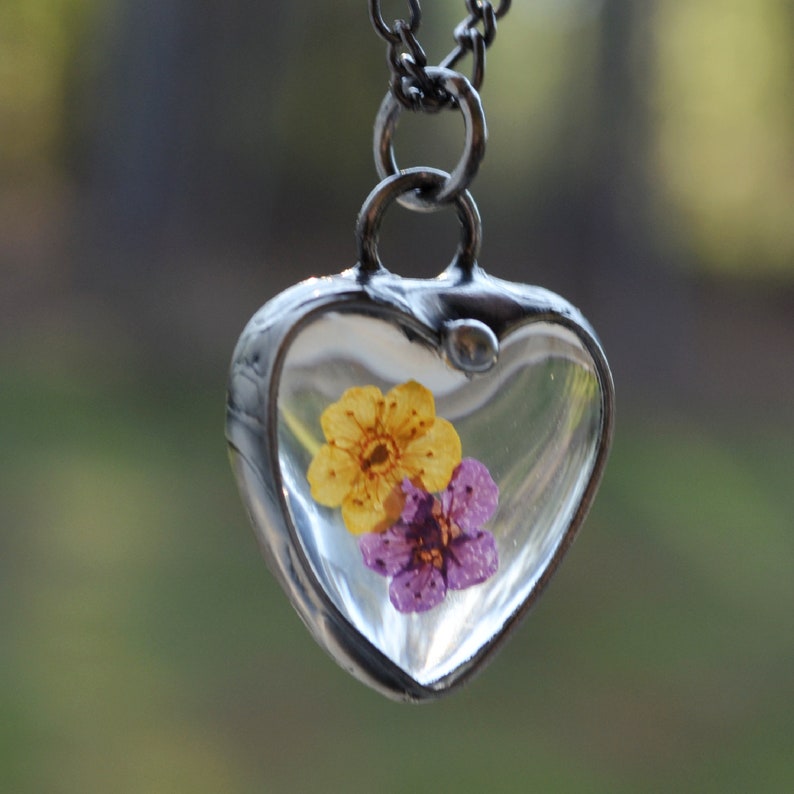 Bright Purple and Yellow forget me not flowers in glass heart pendant necklace, hand made by Louisiana artisans at Bayou Glass Arts in USA
