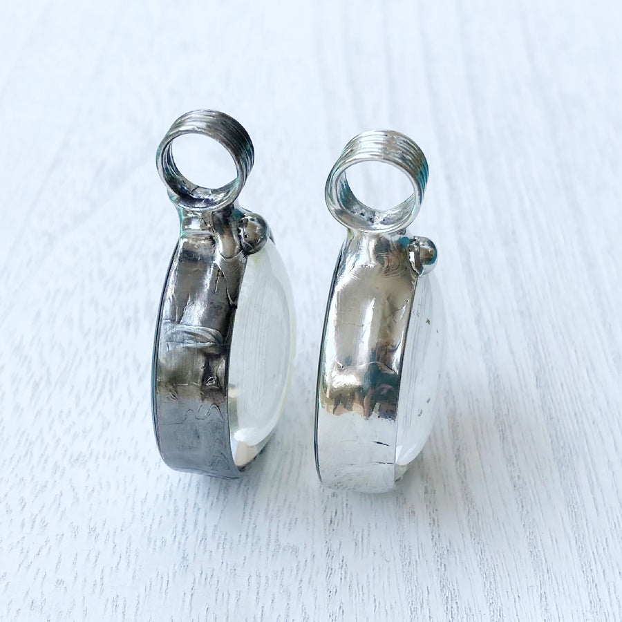 2 Bayou Glass Arts Pendants side by side to show the difference in finishes. Left is gunmetal shiny black finish, right is shiny silver finish.