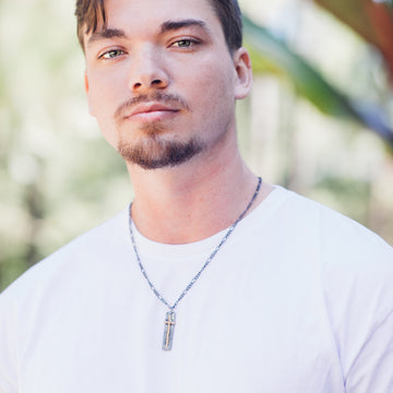 Handsome male model wearing Handmade Cross Necklace. Cross is a silver tone tag with copper wire wrap. Truly handmade in USA.