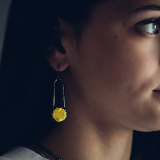 model wearing a yellow ceramic dot earring. Truly hand Made in USA by Louisiana Artisan at Bayou Glass Arts Studio.  Sterling Silver Ear Wires